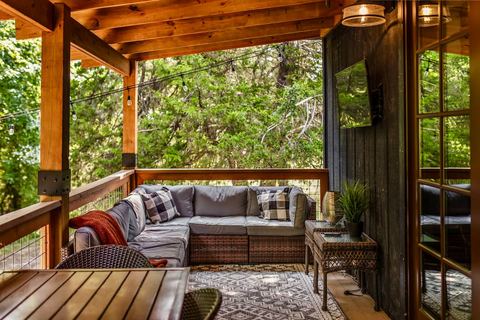 Covered porch sectional with plaid cushions looking out into the trees