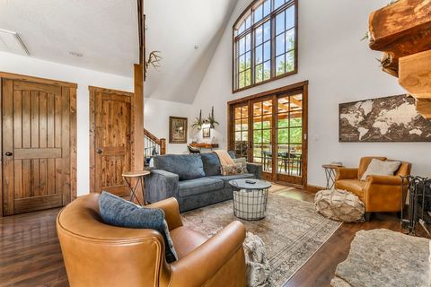 Leather armchair and sofa beneath the cabin’s dramatic two-story window wall