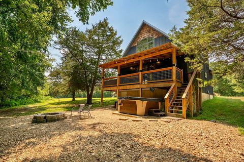 Cabin exterior showing the private hot tub tucked beneath the elevated deck