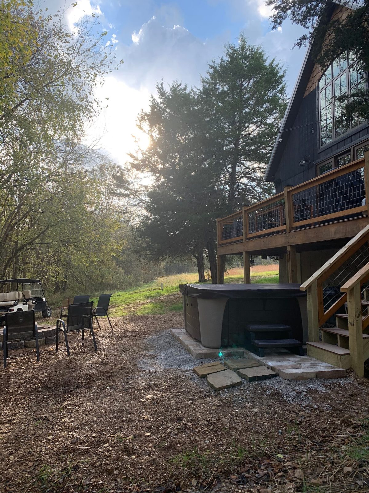 Six-person hot tub under string lights next to the fire pit, usable all year round