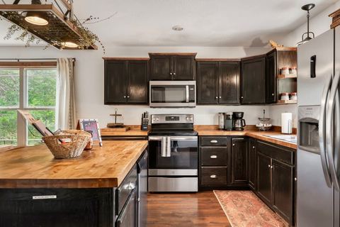 Dark shaker cabinetry with stainless range and microwave in the cabin kitchen