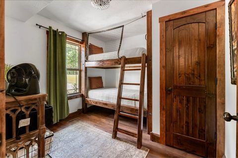 Built-in bunk beds with a timber ladder in the second bedroom