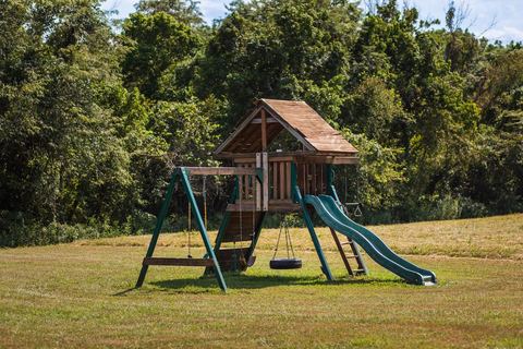 Wooden playground set with swings and a slide — a favorite with visiting families