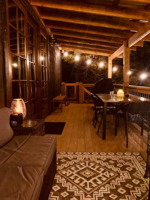 Evening on the covered porch with string lights and comfortable seating