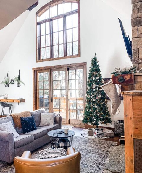 Bright cabin living room with vaulted ceilings and floor-to-ceiling windows overlooking the Ozark woods