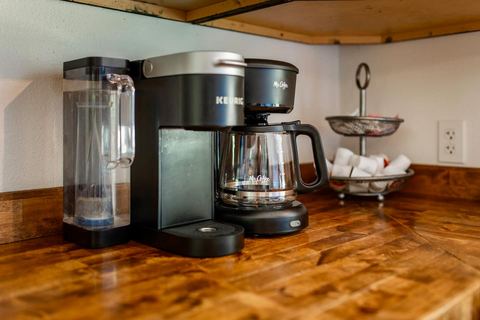 Keurig and drip coffee makers set up on the kitchen counter for guests