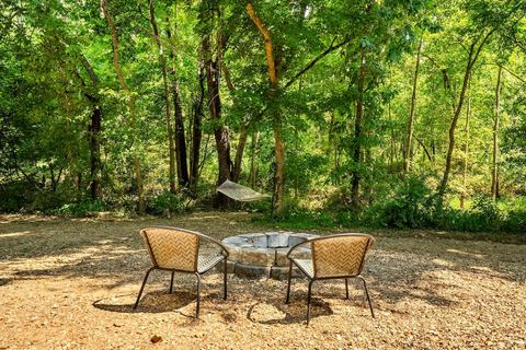 Outdoor fire pit ringed with chairs in a clearing among the trees