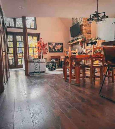Dining area with a farmhouse table set beneath a rustic chandelier